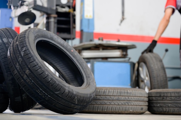 Un changeur de pneus vérifie les nouveaux pneus en stock pour les emmener à un centre de service ou à un atelier de réparation automobile entrepôt de pneus pour l'industrie automobile