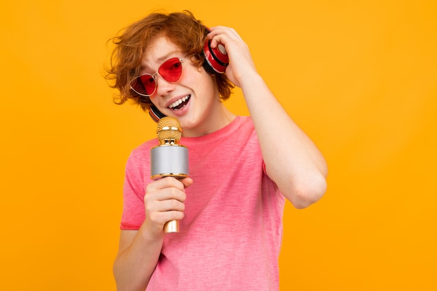 Chanteur de gars aux cheveux roux dans les écouteurs chante sur jaune