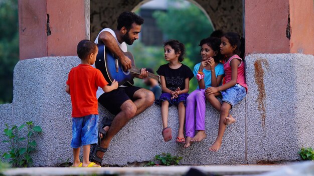 Chanteur jouant de la guitare avec un petit enfant en plein air