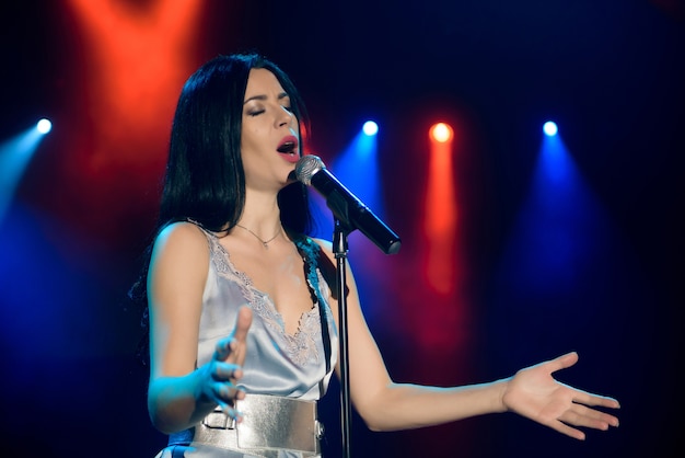 Chanteur avec microphone sur la scène lumineuse colorée