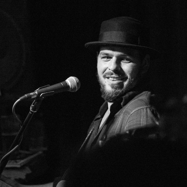 Photo un chanteur souriant portant un chapeau