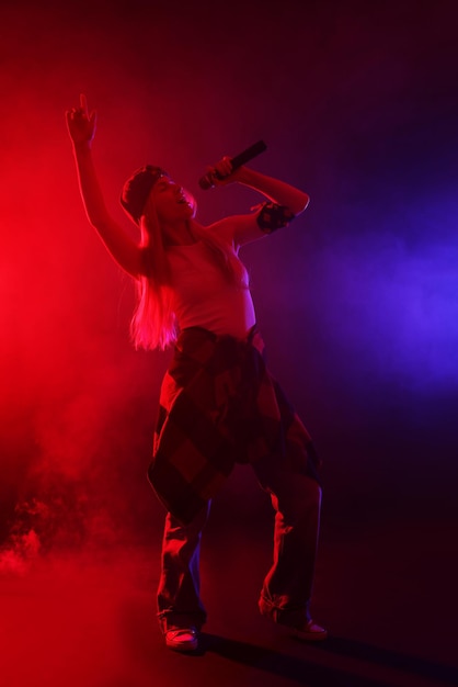 Un chanteur talentueux se produit sur un fond sombre avec des lumières colorées et de la fumée