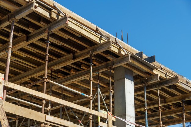 Un chantier de construction en plein air Construction d'un nouveau bâtiment Construction en bloc de poutres en béton armé et de planchers et de toits en bois