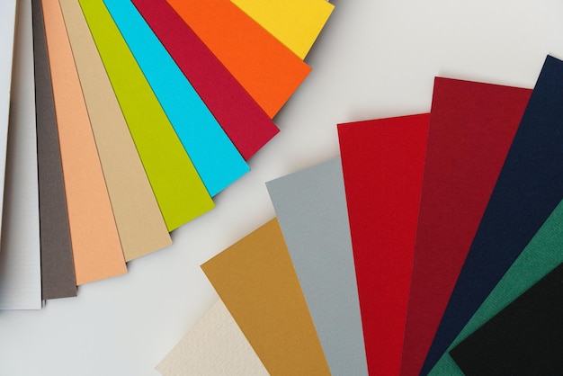 Échantillons de papier coloré sur un bureau blanc en gros plan