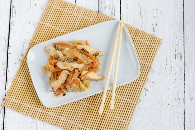 Photo chapchae plat asiatique de nouilles de verre avec du poulet et des légumes