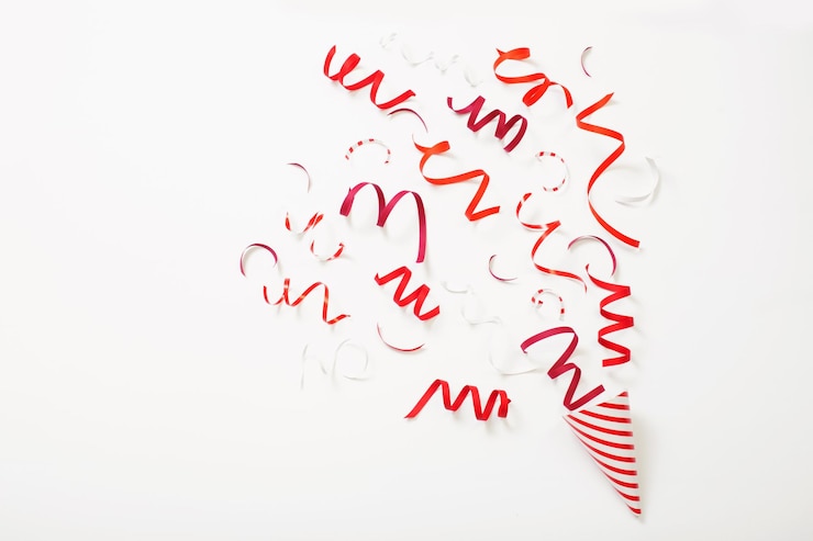 Photo chapeau d'anniversaire rayé avec des confettis sur fond blanc