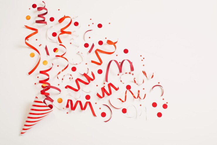 Photo chapeau d'anniversaire rayé avec des confettis sur fond blanc