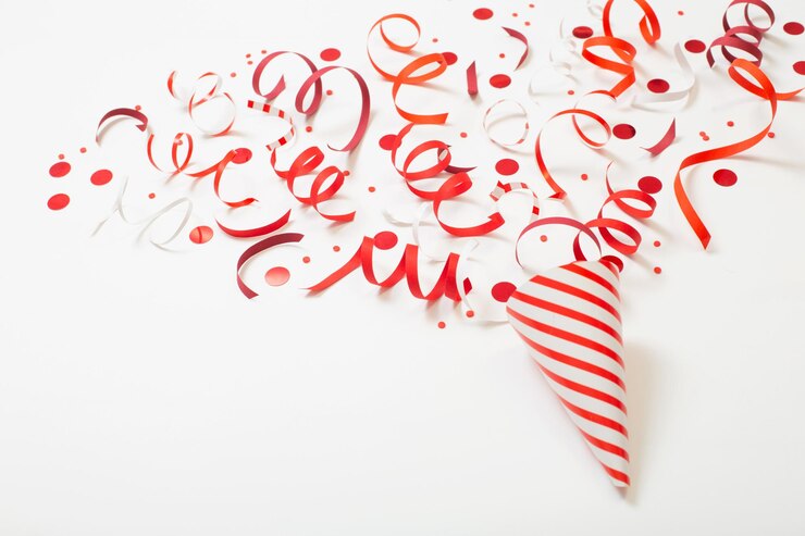 Photo chapeau d'anniversaire rayé avec des confettis sur fond blanc