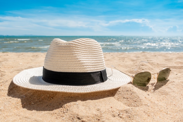 Chapeau blanc et lunettes de soleil sur la plage, concept de l&#39;été