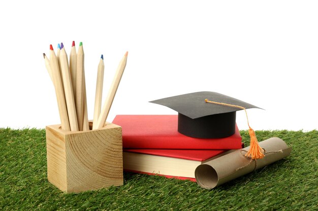 Chapeau de diplômé PNG avec des livres sur de l'herbe isolée sur un fond blanc
