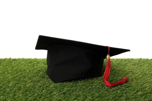 Chapeau de diplômé PNG avec des livres sur de l'herbe isolée sur un fond blanc