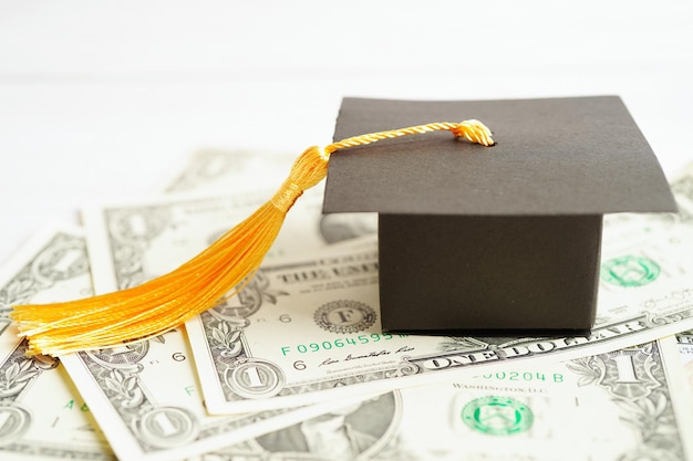 Chapeau d'écart de graduation sur les billets en dollars américains argent frais d'étude de l'éducation apprentissage enseigner le concept