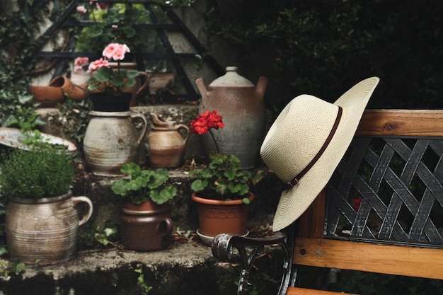 Chapeau d'été pour femmes sur un banc en bois dans le jardin style de vie calme et concept cottagecore