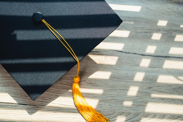 Chapeau de graduation noir Niveau universitaire placé sur une table en bois