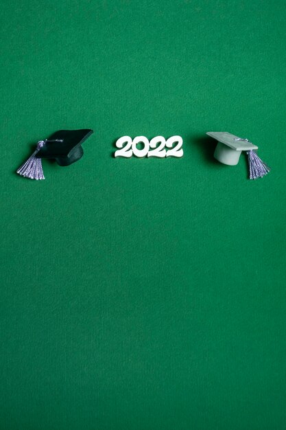 Chapeau de graduation et numéros 2022 sur fond vert, gros plan avec espace de copie. Concept d'éducation médicale. Format vertical