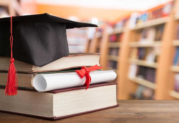 Chapeau de graduation sur pile de livres et diplôme