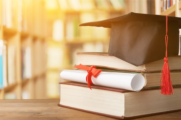 Chapeau de graduation sur pile de livres et diplôme