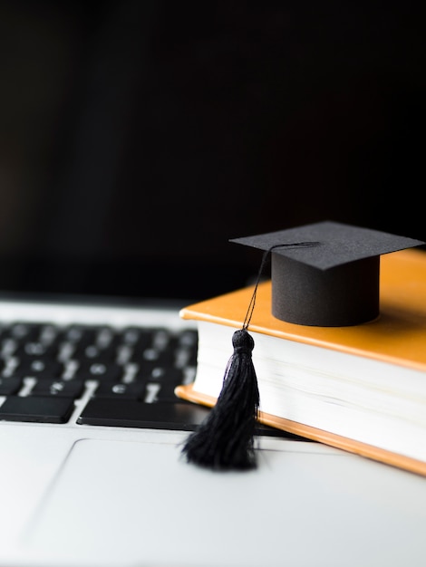 Photo chapeau de graduation sur une pile de livres