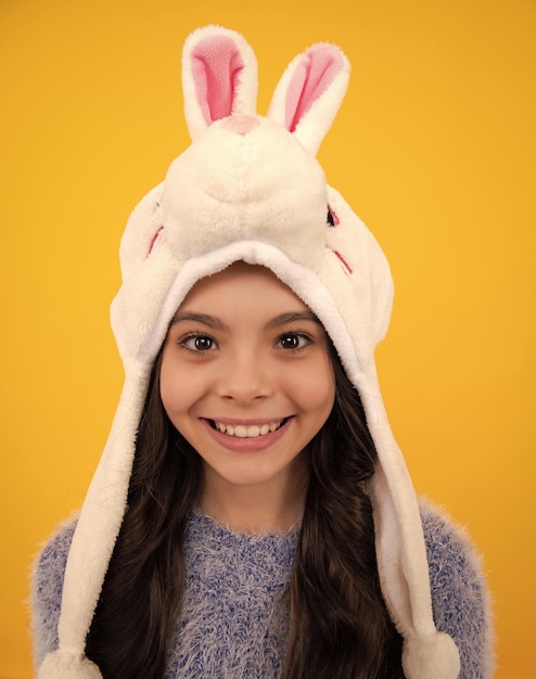 Chapeau d'hiver lapin adolescente moderne portant un pull et un bonnet tricoté sur fond jaune isolé