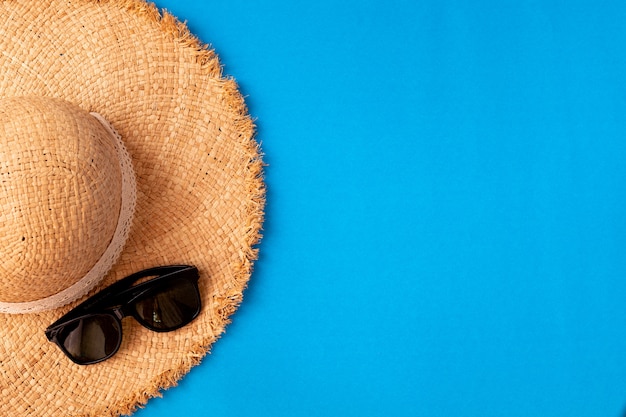 Chapeau de laddies en bois et lunettes de soleil sur bleu