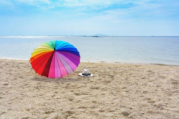 Chapeau lunettes de soleil et parapluie de couleur arc-en-ciel sur une plage tropicale Pattaya Thaïlande