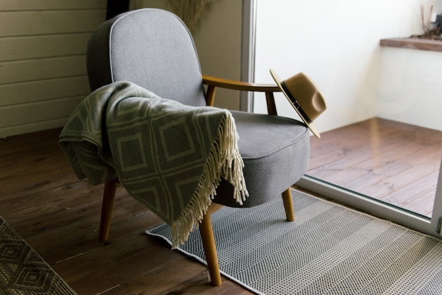 Un chapeau marron accroché sur une chaise grise