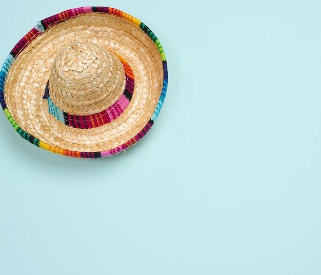 Chapeau mexicain de paille sur la vue de dessus de fond bleu