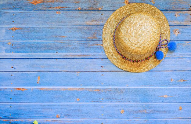 Photo chapeau de paille femme sur fond de bois bleu