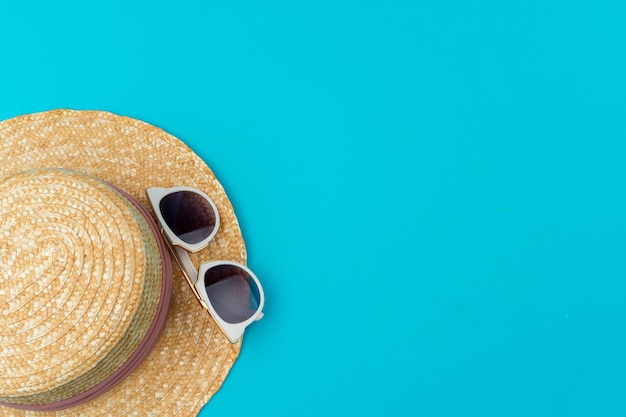 Chapeau de paille femme et lunettes de soleil pour les vacances à la plage vue de dessus