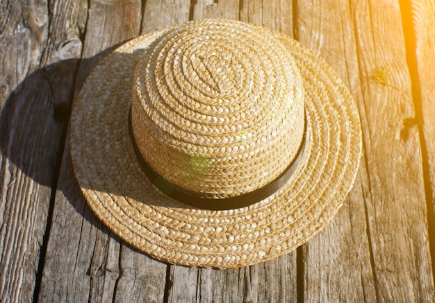 Photo chapeau de paille sur la jetée en bois photo rustique et naturelle à l'extérieur rivière d'été détente et concept de voyage wanderlust touristes randonnées