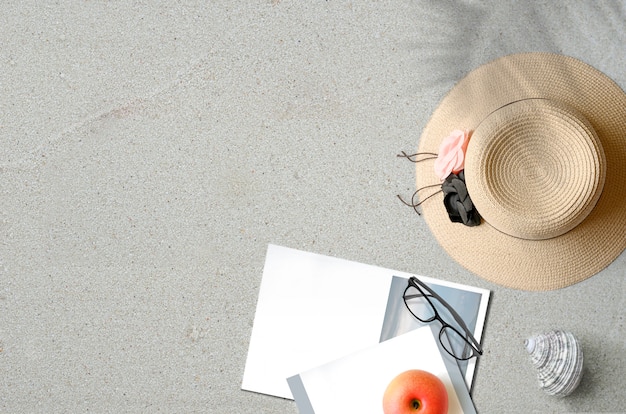 Chapeau de paille avec livre sur le sable avec copie espace Concept d'été
