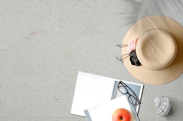 Chapeau de paille avec livre sur le sable avec copie espace Concept d&#39;été