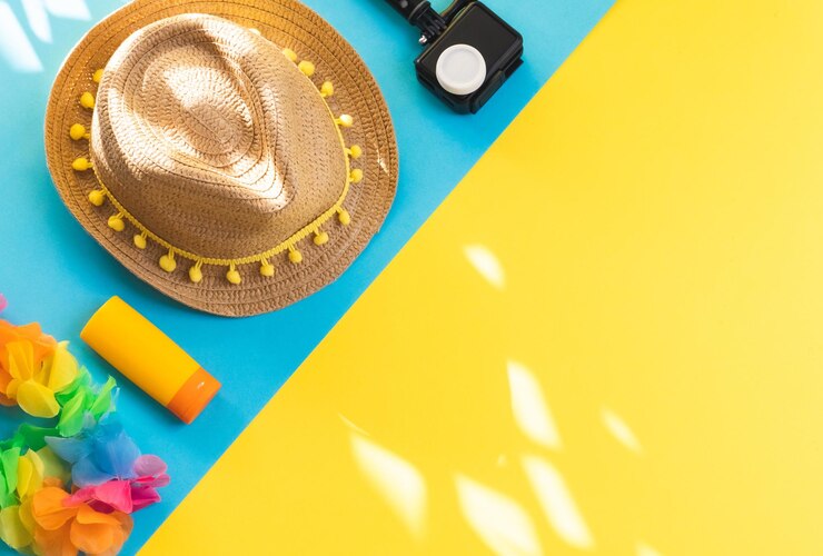 Photo chapeau de paille et lunettes de soleil sur fond jaune