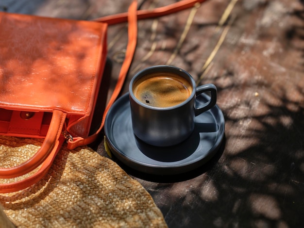 Chapeau de paille sac orange et délicieux café sur la table en bois