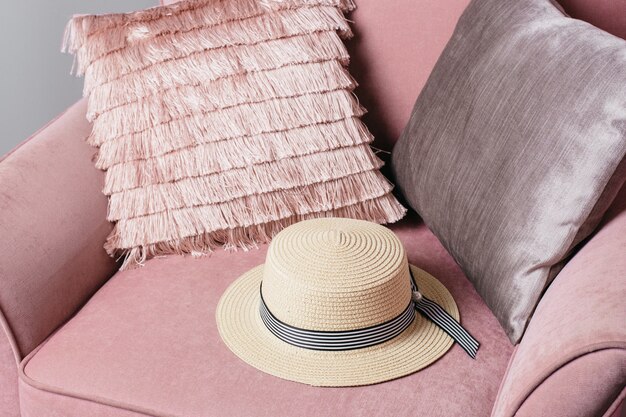 Chapeau de paille sur une surface de chaise rose