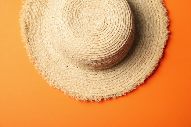 Photo chapeau de paille sur surface orange