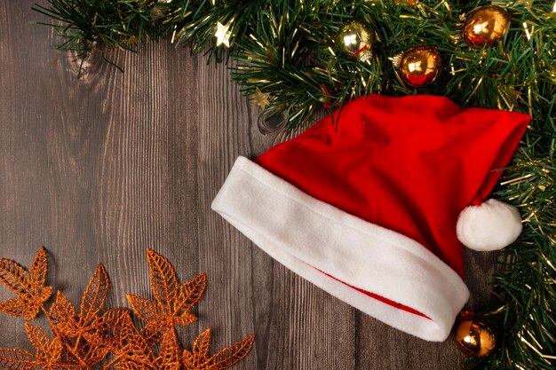 Chapeau de père Noël avec décorations de Noël sur table en bois.