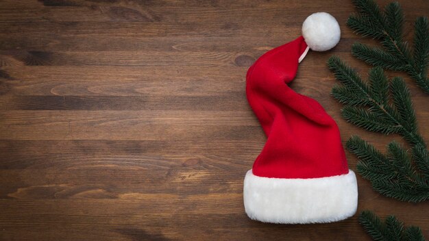 Chapeau de Père Noël sur un fond en bois avec des flocons de neige volants Noël Nouvel An