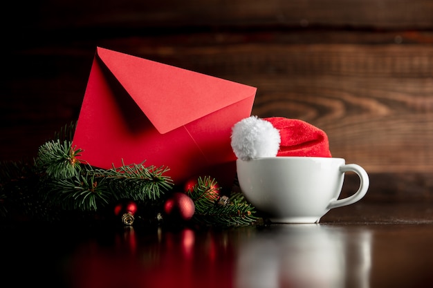 Chapeau de père Noël et tasse avec enveloppe