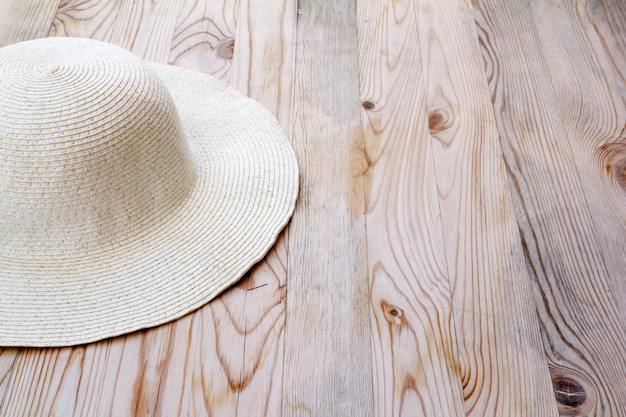 chapeau de plage blanc sur pin clair