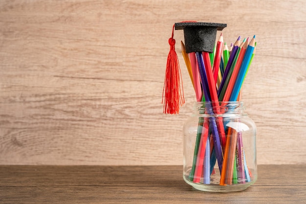 Chapeau de remise des diplômes avec des crayons colorés avec espace de copie, apprentissage du concept d'enseignement universitaire.