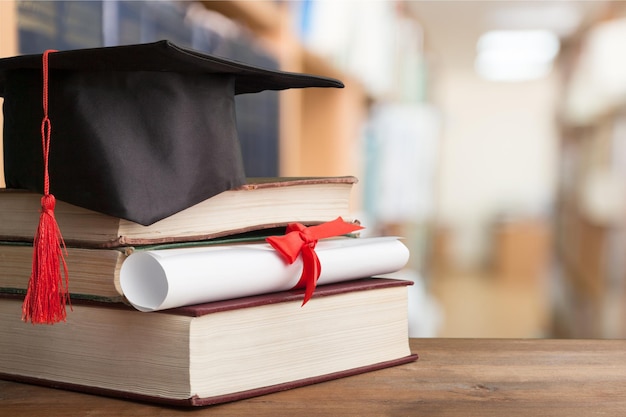 Chapeau de remise des diplômes sur pile de livres