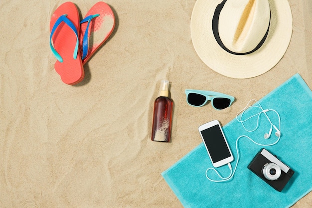 chapeau smartphone flip flops et nuances sur la plage