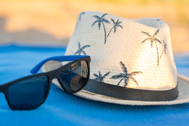 Chapeau de soleil et lunettes de soleil sur une couverture de plage concept de vacances d'été