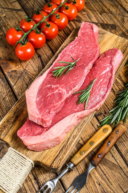 Chapeau de surlonge cru ou steak de picanha sur une planche à découper.