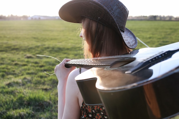 Photo chapeau de texas de coucher du soleil de champ extérieur de fille