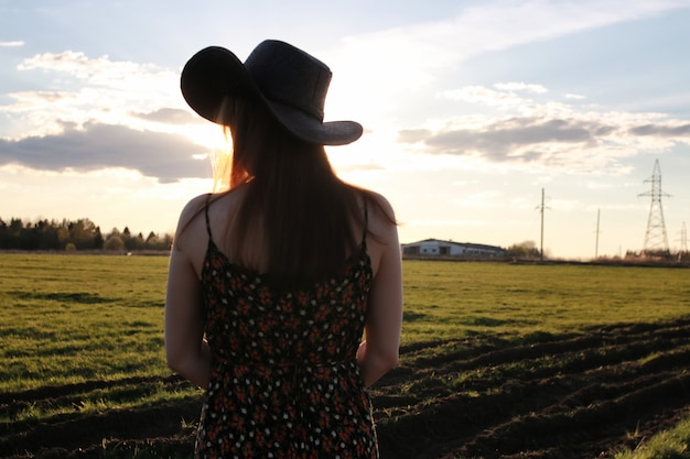 Chapeau de texas de coucher du soleil de champ extérieur de fille