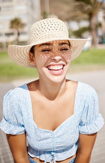 Chapeau de voyage et fille d'été avec le sourire appréciant le temps chaud des vacances au soleil en plein air