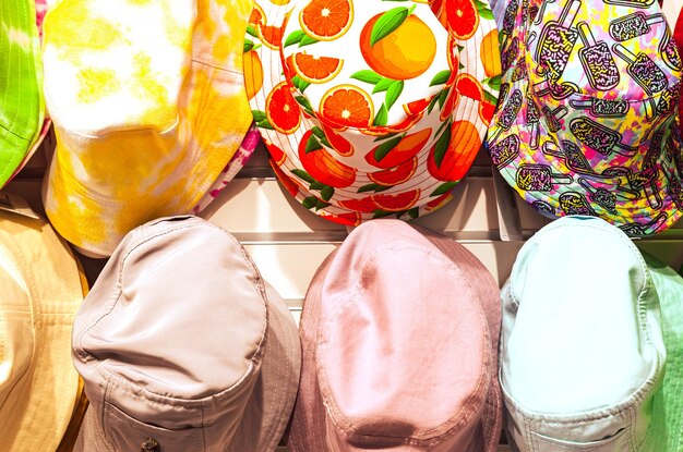 Chapeaux d'été de différentes couleurs dans le magasin gros plan Panamas d'été multicolores accrochés dans le magasin