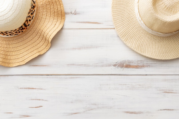 Chapeaux de paille de fond d'été sur un fond en bois clair